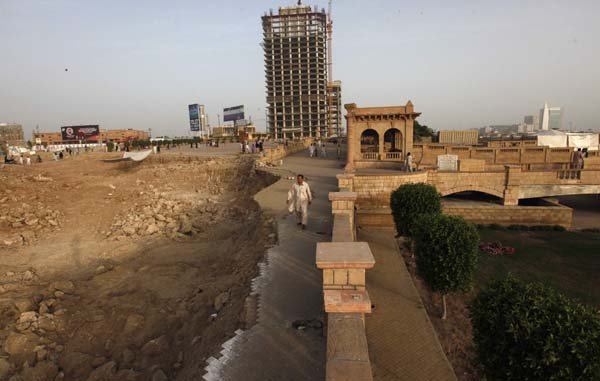 A man walks past the construction of an underpass and a flyover near the 150-year-old Shri Ratneshwar Mahadev temple