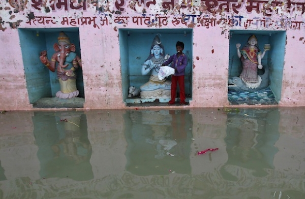 A boy stands next to an idol of Hindu Lord Shiva at a temple during a flood in this file picture taken on September 2, 2013. Muslim residents at Puncak Alam today protested against the planned construction of a Hindu temple in the area. — Reuters pic.