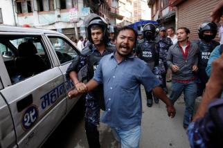 Nepalese police detain a protester during a demonstration against the government and the new constitution during in Kathmandu, Nepal, Sunday, Sep 20, 2015. Police quickly dispersed the protest and two people were detained. Police were under orders to stop any protests. Schools and offices are closed because Sunday and Monday were declared a public holiday to celebrate the constitution, Nepal's first complete political framework since monarchy was abolished in 2006. (AP Photo/Niranjan Shrestha)