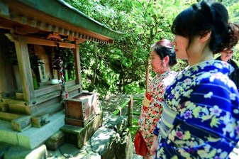 Women worshipping in front of Benzaiten (Saraswati) Temple  in Japan.