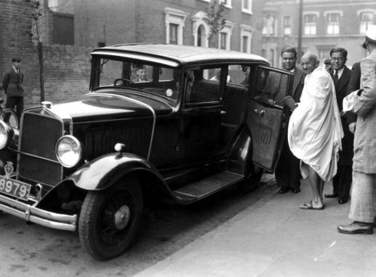 UNITED KINGDOM - SEPTEMBER 26: Mahatma Gandhi in London, 2 October 1931. Gandhi entering a car outside Kingsley Hall. Gandhi (1869-1948) is remembered for his civil disobedience policy against British rule in India and his belief in non-violent protest. Gandhi was involved in negotiations with the British over Indian independence. In 1931, he came to London to attend the Round Table conference on Indian constitutional reform and in 1946 he was involved in the new constitutional structure for independent India. He was assassinated in September 1948. Photograph by Harold Tomlin. (Photo by Daily Herald Archive/SSPL/Getty Images)